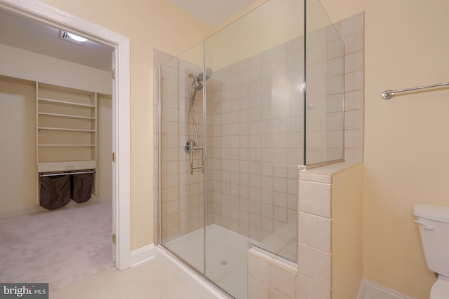 bathroom featuring a tile shower and toilet