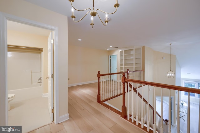 hall featuring light hardwood / wood-style flooring and a notable chandelier