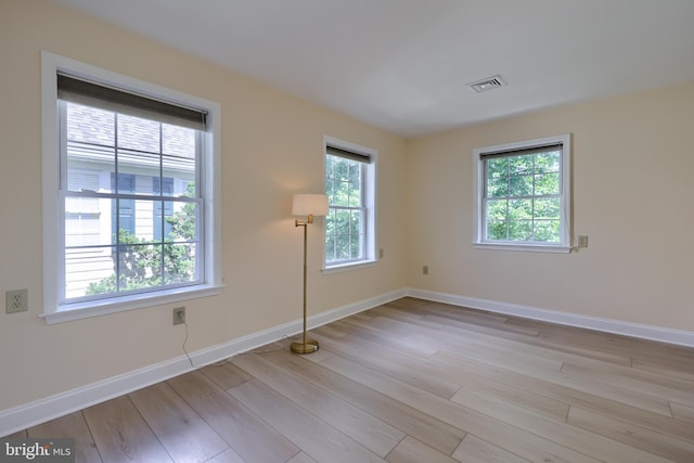 unfurnished room featuring a healthy amount of sunlight and light hardwood / wood-style floors