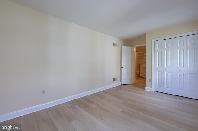 unfurnished bedroom featuring light wood-type flooring and a closet