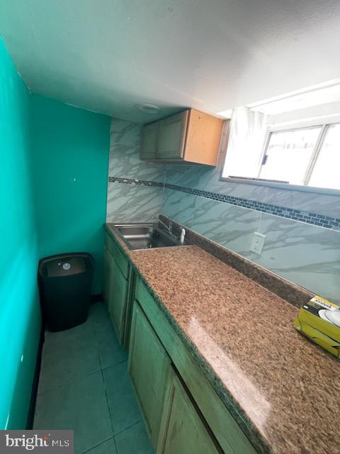 kitchen featuring light tile patterned floors and sink