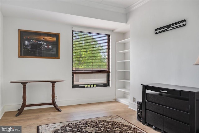 living area featuring light hardwood / wood-style flooring, built in features, and ornamental molding