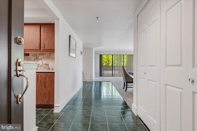 hall with dark tile patterned floors