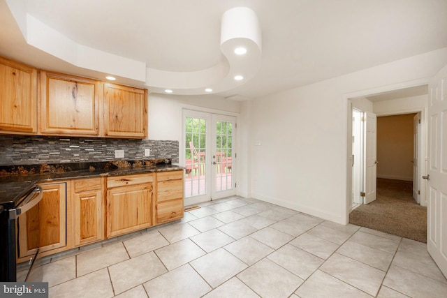 kitchen with french doors, tasteful backsplash, dark stone counters, a tray ceiling, and range