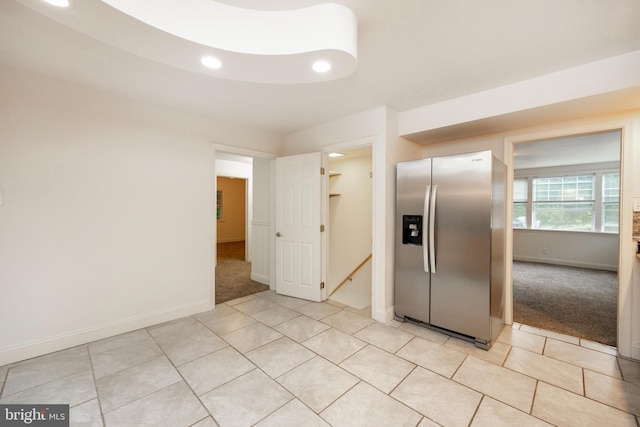 kitchen with stainless steel fridge and light colored carpet