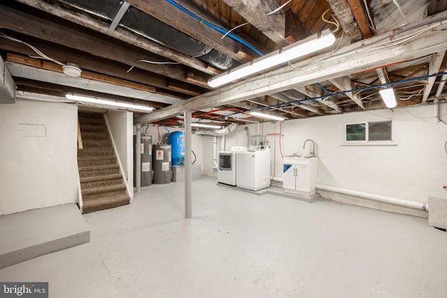 basement with sink, electric water heater, and washing machine and clothes dryer