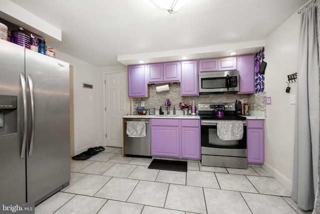 kitchen featuring appliances with stainless steel finishes, tasteful backsplash, light tile patterned floors, and sink