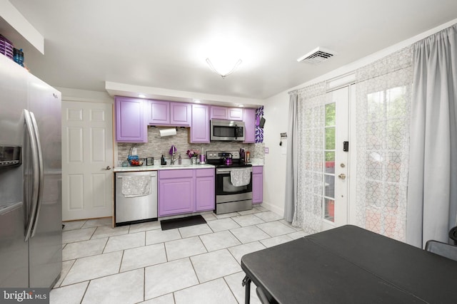 kitchen featuring tasteful backsplash, sink, light tile patterned floors, and appliances with stainless steel finishes