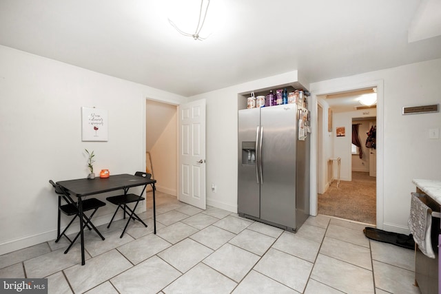 kitchen featuring stainless steel refrigerator with ice dispenser and light colored carpet