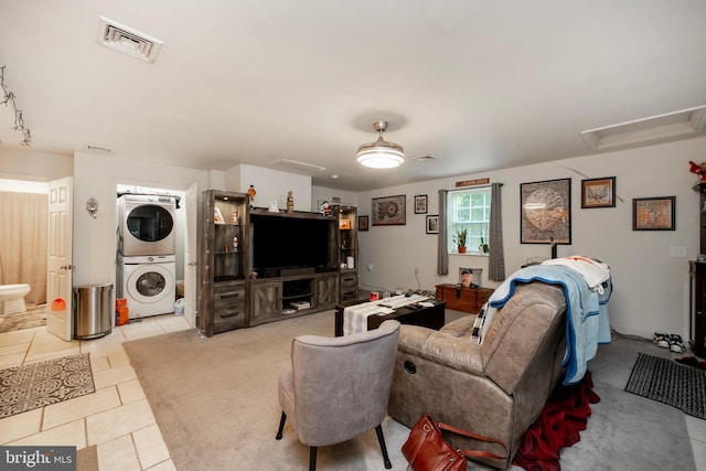 living room with light tile patterned floors and stacked washer and clothes dryer