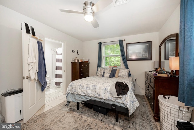 bedroom with tile patterned floors, ensuite bathroom, and ceiling fan