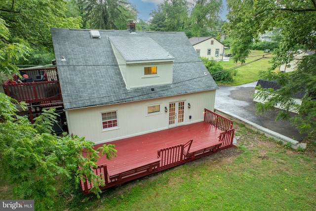 back of property featuring a lawn, a wooden deck, and french doors