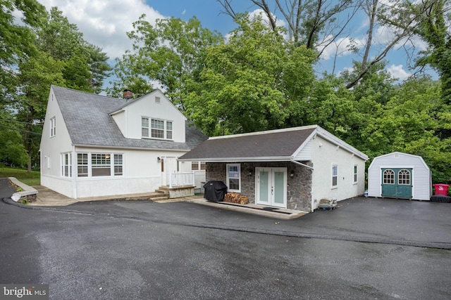 view of front of house featuring an outdoor structure and french doors