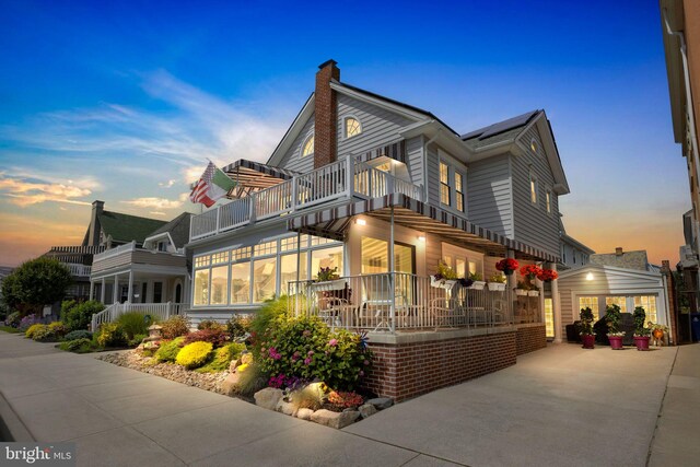 view of home's exterior featuring a sunroom, a balcony, and a garage