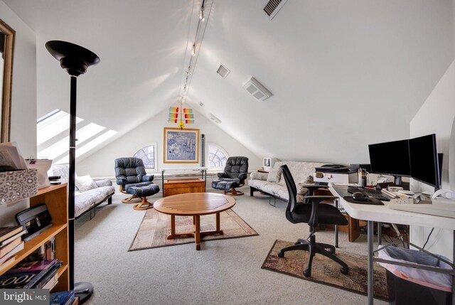 carpeted living room with lofted ceiling with skylight and track lighting