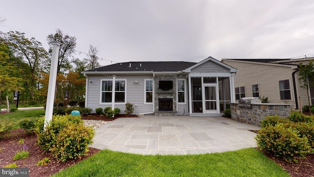 back of house featuring area for grilling, a patio area, and a sunroom