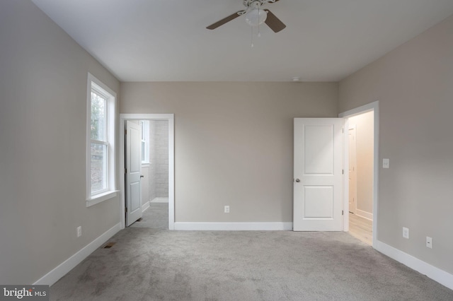 unfurnished bedroom with ensuite bathroom, ceiling fan, and light colored carpet