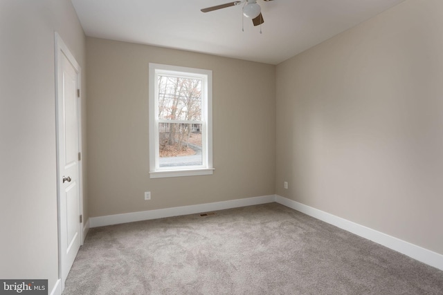 empty room featuring light colored carpet and ceiling fan