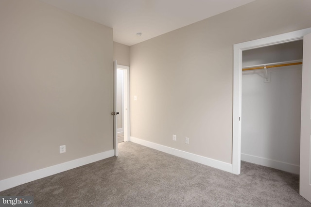 unfurnished bedroom featuring light carpet and a closet