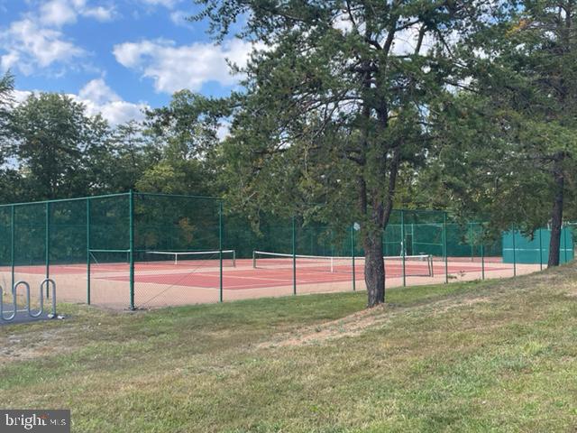 view of tennis court with a yard