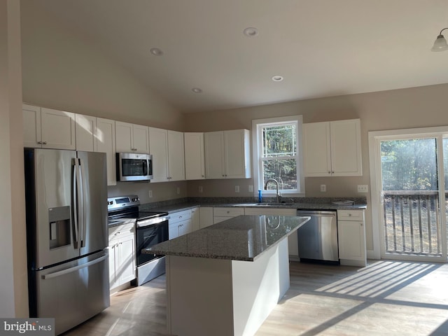 kitchen featuring appliances with stainless steel finishes, plenty of natural light, white cabinetry, and a center island