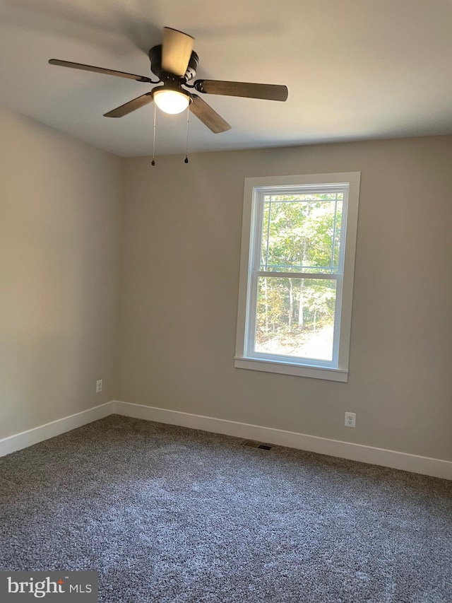 carpeted spare room featuring ceiling fan