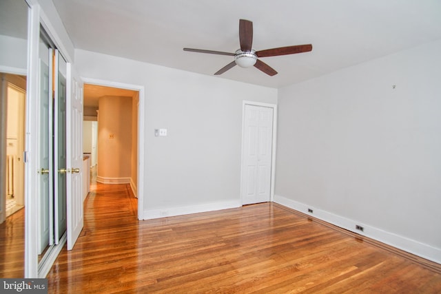 unfurnished bedroom with ceiling fan, wood-type flooring, and a closet