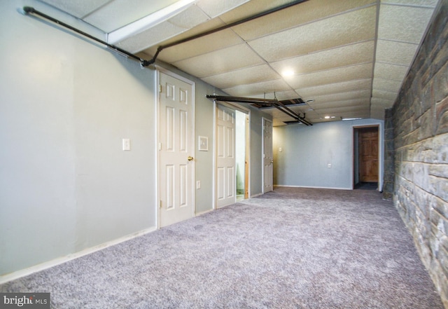 basement featuring carpet and a paneled ceiling