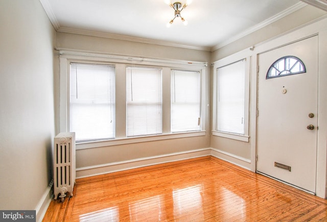 entrance foyer featuring radiator, ornamental molding, and light wood-type flooring