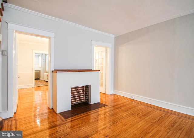 unfurnished living room featuring crown molding and hardwood / wood-style floors