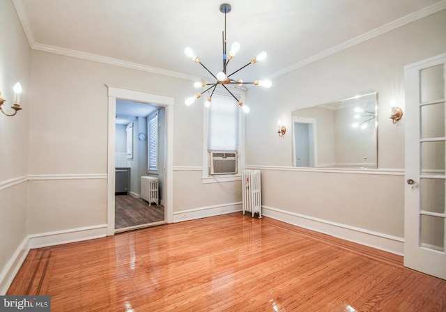 unfurnished dining area with radiator, ornamental molding, and wood-type flooring