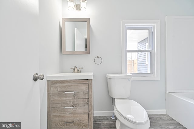 bathroom featuring toilet, hardwood / wood-style floors, and vanity