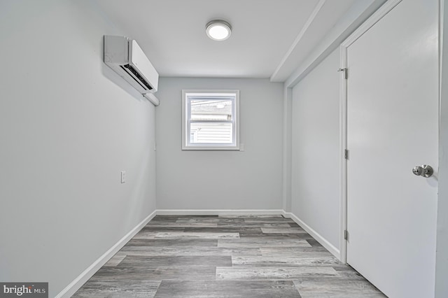 interior space with hardwood / wood-style flooring and a wall unit AC