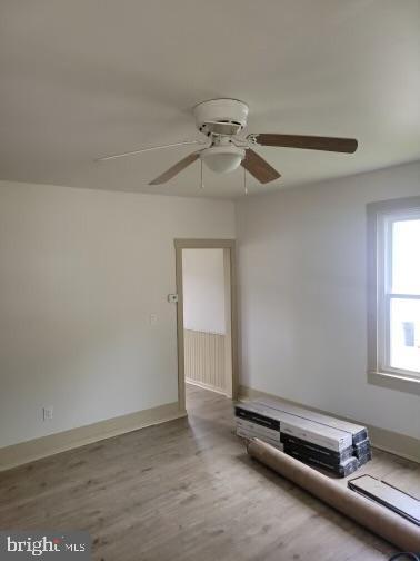 empty room featuring light wood-type flooring and ceiling fan