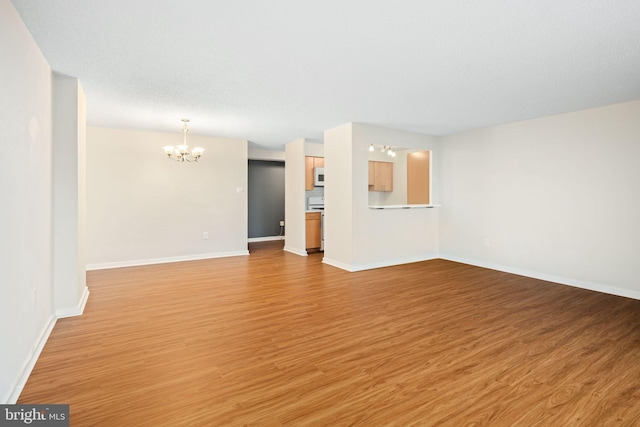 unfurnished living room featuring light hardwood / wood-style flooring and a notable chandelier