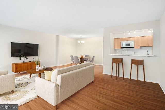 living room with light hardwood / wood-style floors and a chandelier