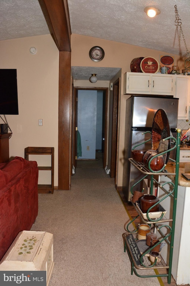 hall featuring a textured ceiling and light colored carpet