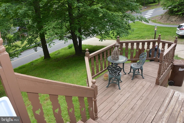 wooden terrace featuring a lawn