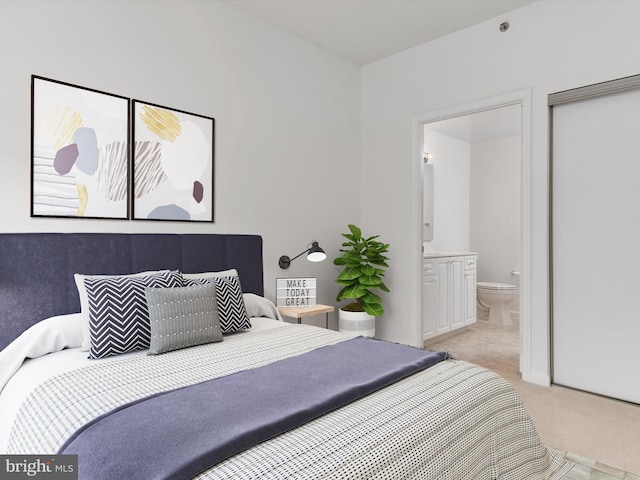 bedroom with light colored carpet and ensuite bath