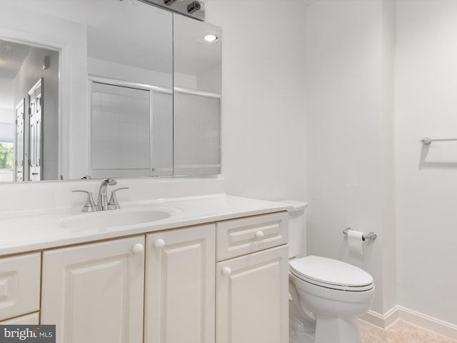 bathroom with tile patterned flooring, vanity, toilet, and a shower with shower door