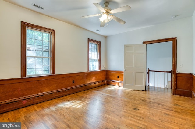 spare room featuring light hardwood / wood-style floors, a baseboard heating unit, and ceiling fan