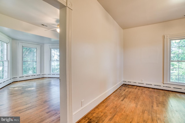 spare room featuring plenty of natural light, ceiling fan, and hardwood / wood-style flooring