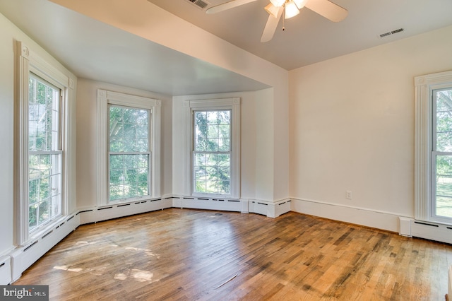 unfurnished room featuring a baseboard radiator, light wood-type flooring, and ceiling fan