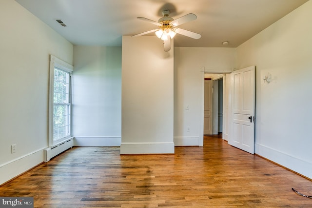 unfurnished room with ceiling fan, hardwood / wood-style floors, and plenty of natural light