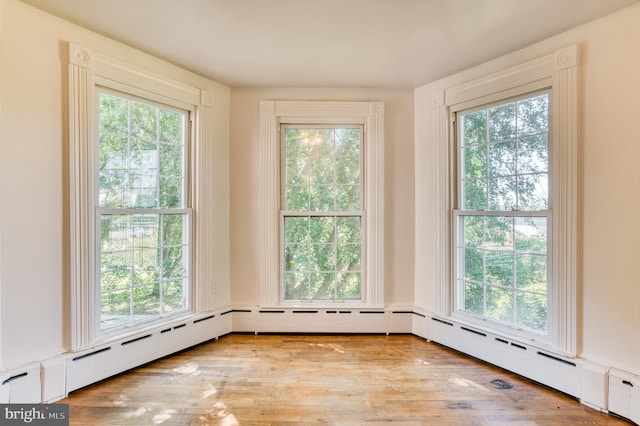 spare room with baseboard heating and hardwood / wood-style flooring