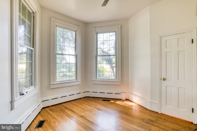 empty room featuring hardwood / wood-style flooring, plenty of natural light, and ceiling fan