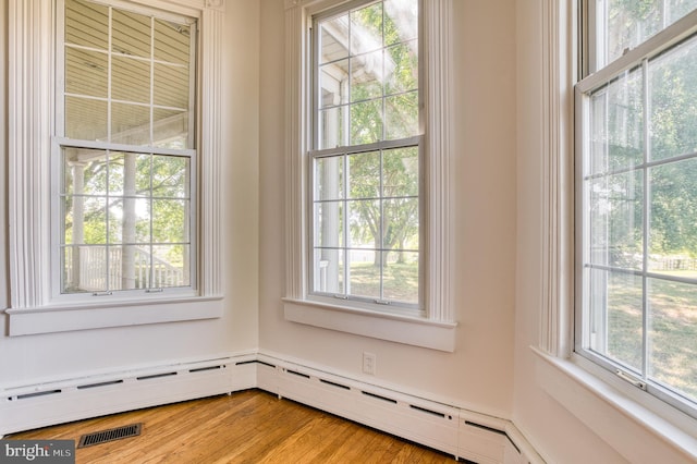 interior details with baseboard heating and hardwood / wood-style flooring