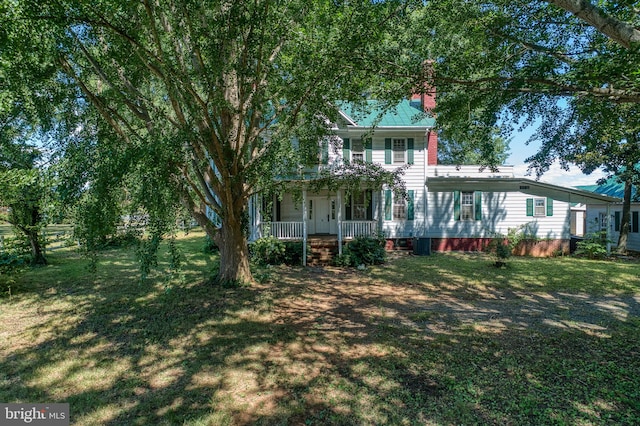 colonial inspired home with a front lawn and covered porch