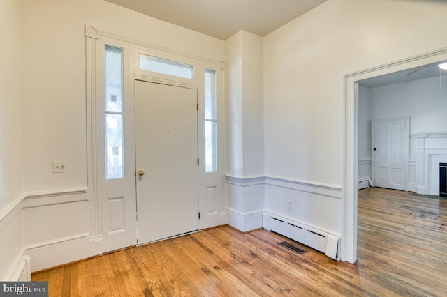 foyer featuring baseboard heating and light wood-type flooring