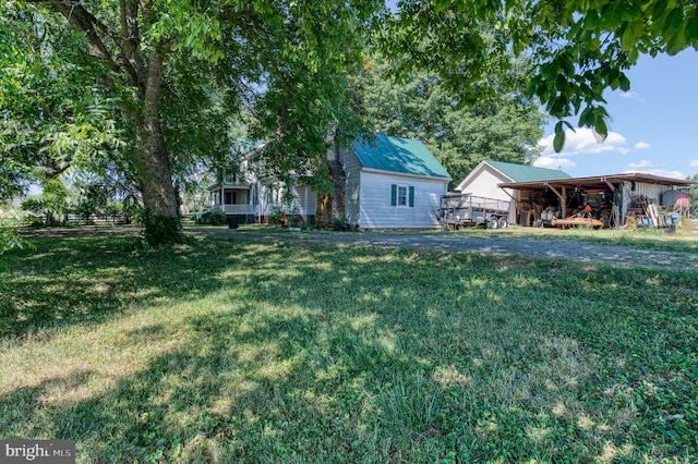 view of yard featuring a carport and an outbuilding